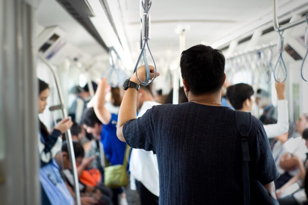 Man standing inside the train wearing BOUNZE Daily Performance Insoles for all-day commuting comfort and support