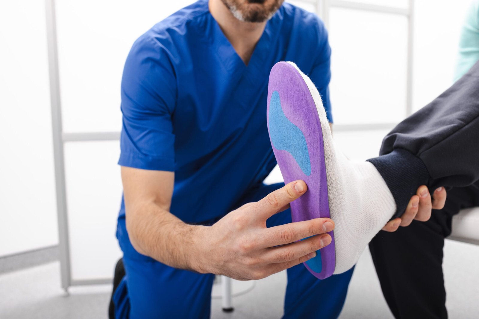 Orthopedist fitting individual orthopedic insole for patient flat foot