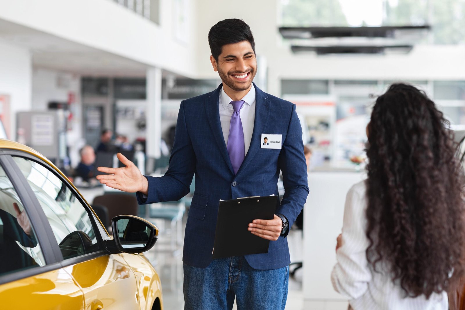 Car dealer on the showroom floor smiling with confidence, supported by custom insoles for standing all day