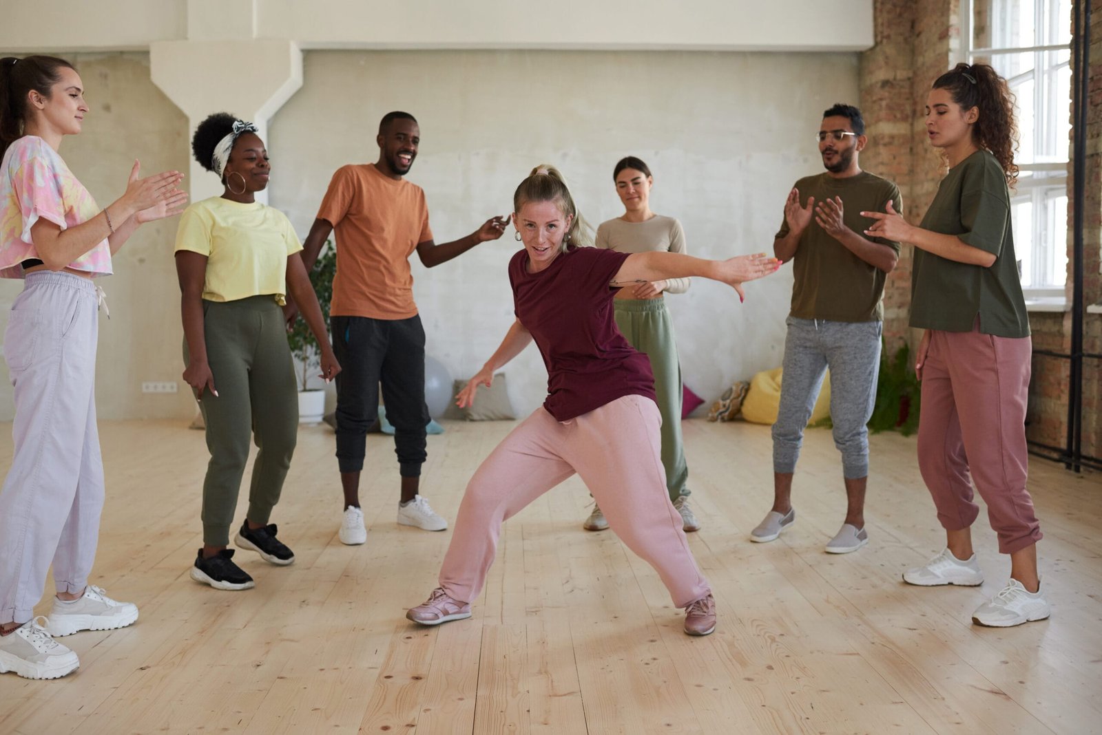 A group of dancers getting comfortable during rehearsal, highlighting the need for supportive insoles for dancing shoes