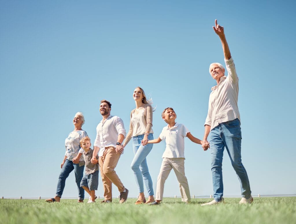 Happy multi-generational family walking outdoors on grass, enjoying pain-free movement with plantar fasciitis pain insoles